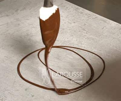 <p>Sumergir una espátula en un tazón con chocolate temperado y dejarlo caer en forma de hilo sobe la charola; mover la espátula de manera circular o de arriba hacia abajo para formar diseños con círculos o líneas.</p>
