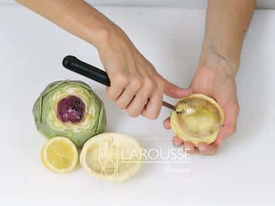 <p>Retire los pistilos o “pelusa” con una cuchara. Sumerja los corazones de alcachofas en agua fría con gotas de jugo de limón para evitar su oxidación.</p>
