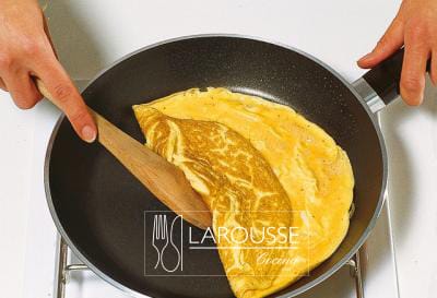 <p>Mantenga el sartén en el fuego sin moverlo durante unos segundos para que se forme una capa crujiente en la base del omelet. Después, doble los bordes del omelet hacia el centro para recubrir la parte más esponjosa.</p>
