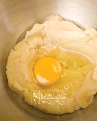 <p>Colocar la masa en una batidora eléctrica y batirla con la pala. Agregar los huevos gradualmente cuidando que estén integrados totalmente antes de añadir el siguiente.</p>
