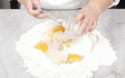<p>Forme con la harina un círculo hueco sobre una mesa y vacíe en el centro los ingredientes restantes.</p>
