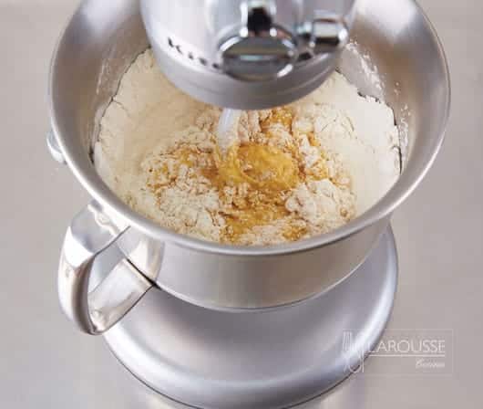 <p>Mezcle en la batidora la harina de trigo con el interior de la vaina de vainilla o el extracto, el azúcar y la sal. Batiendo a velocidad baja, agregue la levadura en polvo, las yemas y la masa madre.</p>
