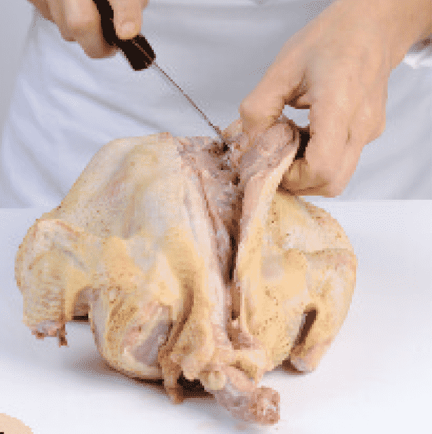 <p>Con el pollo boca abajo, corte a lo largo de la columna con un cuchillo hasta atravesar los huesos.</p>
