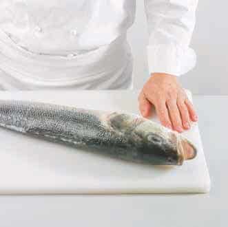 <p>Disponga el pescado en diagonal sobre la tabla, con la cabeza a la izquierda y el dorso hacia arriba</p>

