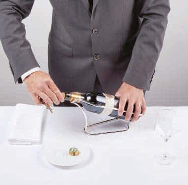 <p>Termine de retirar el tapón o corcho con los dedos, dejando que entre aire por arriba para que el nivel del vino baje por el gollete.</p>
