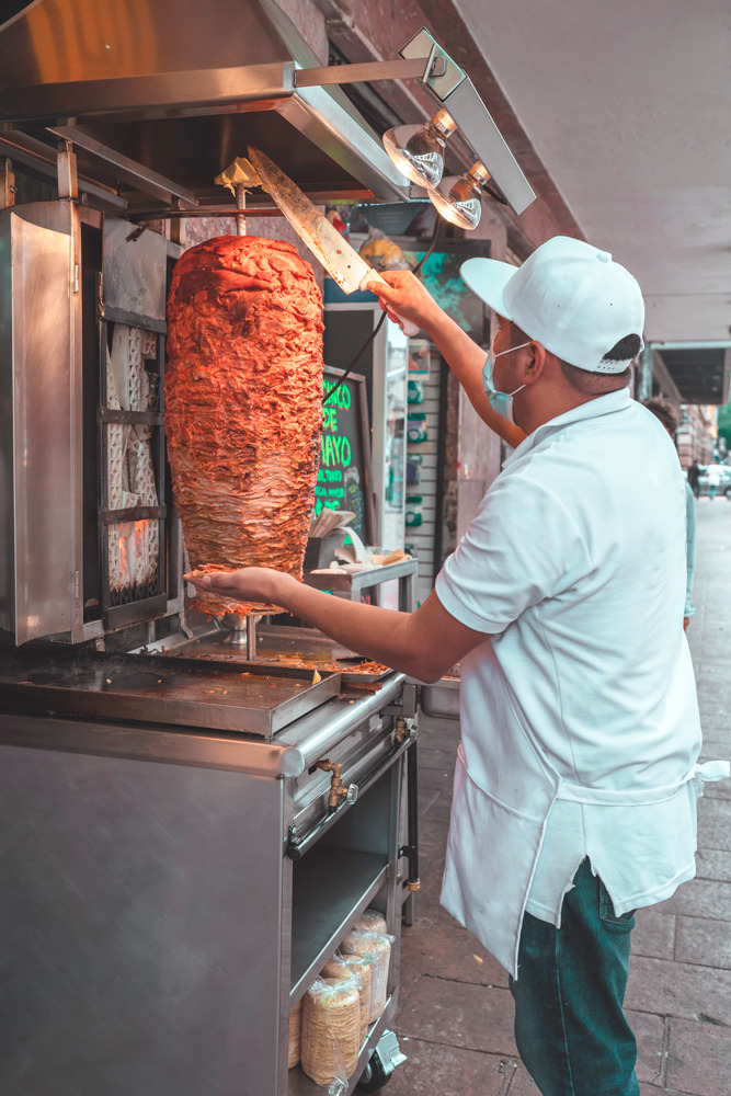 Taquero especializado en la venta de tacos al pastor. Fuente de la imagen: Archivo fotográfico de Larousse Cocina.